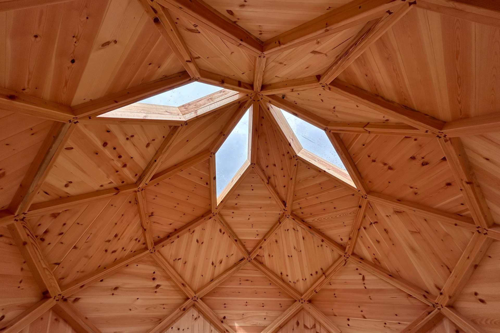 Innenansicht einer geodätischen Kuppel aus Holz mit präziser, heiliger Geometrie – gefertigt in Südtirol
